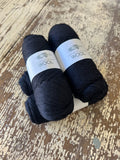 Two balls of Navy Kangaroo Island Wool yarn on a wooden surface